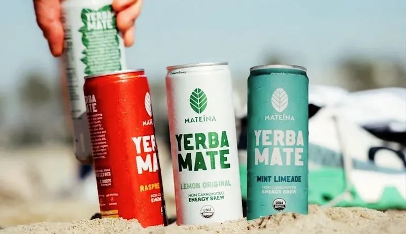 Mateina yerba mate cans standing in beach sand